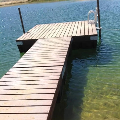 Outdoor Water Solutions Gangway extending into a calm body of water attached to a floating dock