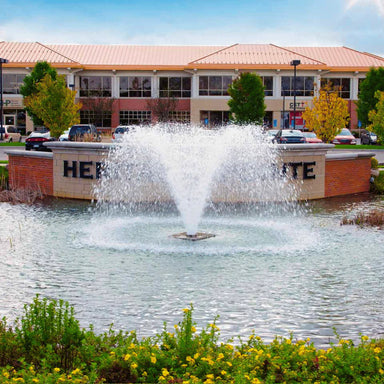 Scott Aerator North Star Aerating Fountain in business park entry with office building in back