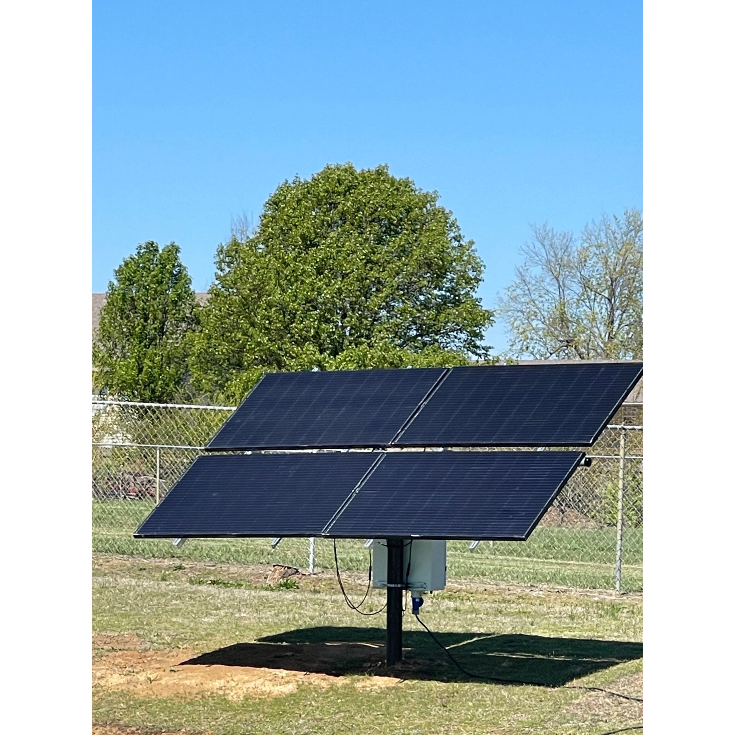 Outdoor Water Solutions Aerify Solar Solar panels on a stand with trees and clear sky in the background