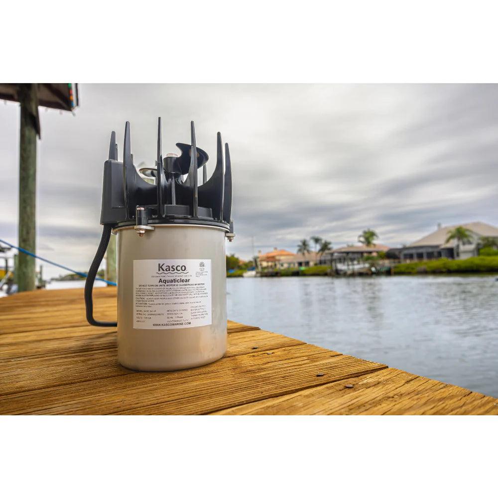 AquatiClear by Kasco Circulator standing upright on a wood dock nest to a lake with homes in the background