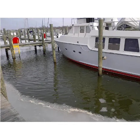 Boat in icy water at dock with ice around the boat cleared away by Ice Eater P750