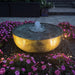 Brass reflection bowl fountain lit at night with fountain lighting