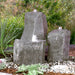 Twisting Cascade triple boulder fountain in a garden setting