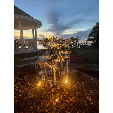 Copper extra tall oak tree fountain lit at night