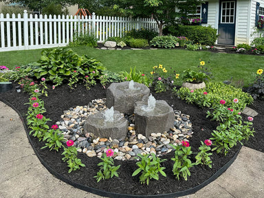 Blue Thumb Triple Falls GFRC boulder fountain kit in a landscaped yard