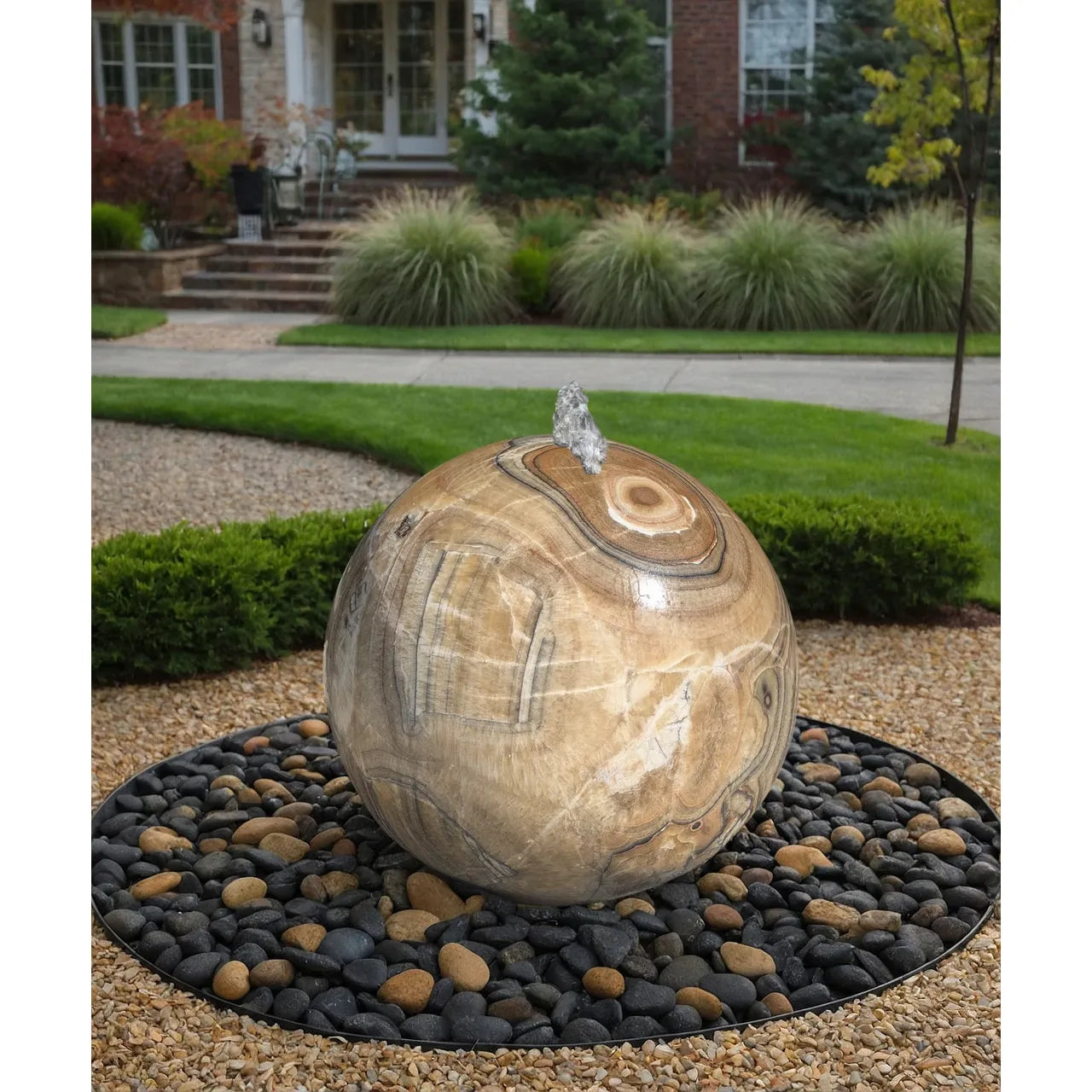 30 inch yellow onyx sphere fountain in a garden setting