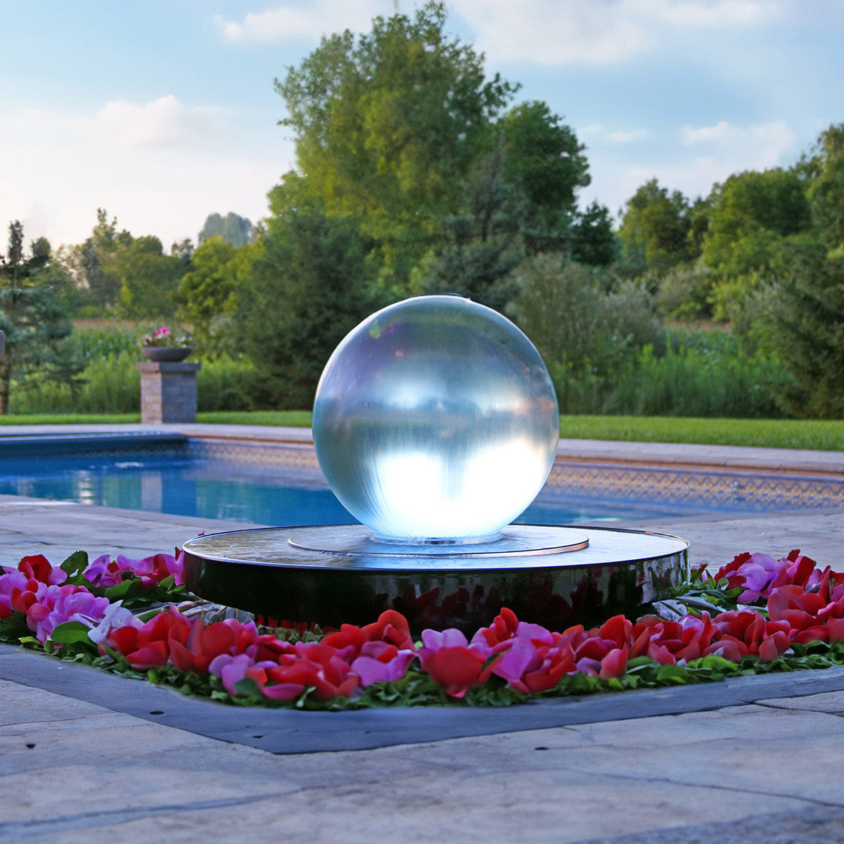 24 inch crystal sphere fountain beside a pool with red flowers