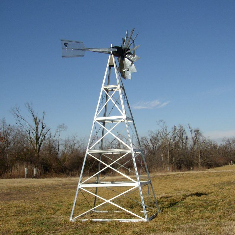 Outdoor Water Solutions Windmill Aerator in field with trees in background