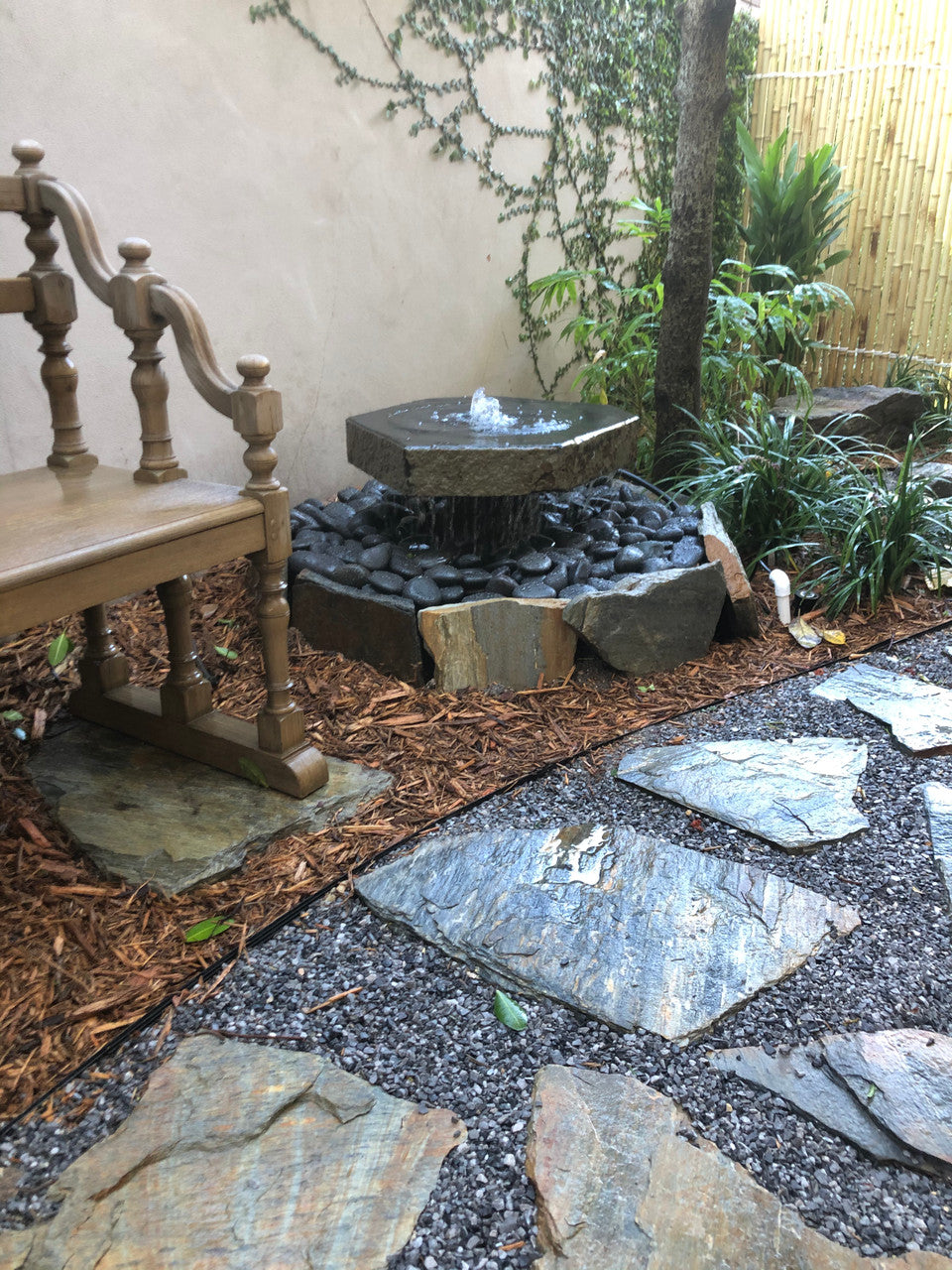 Bird visiting a basalt bird bath fountain