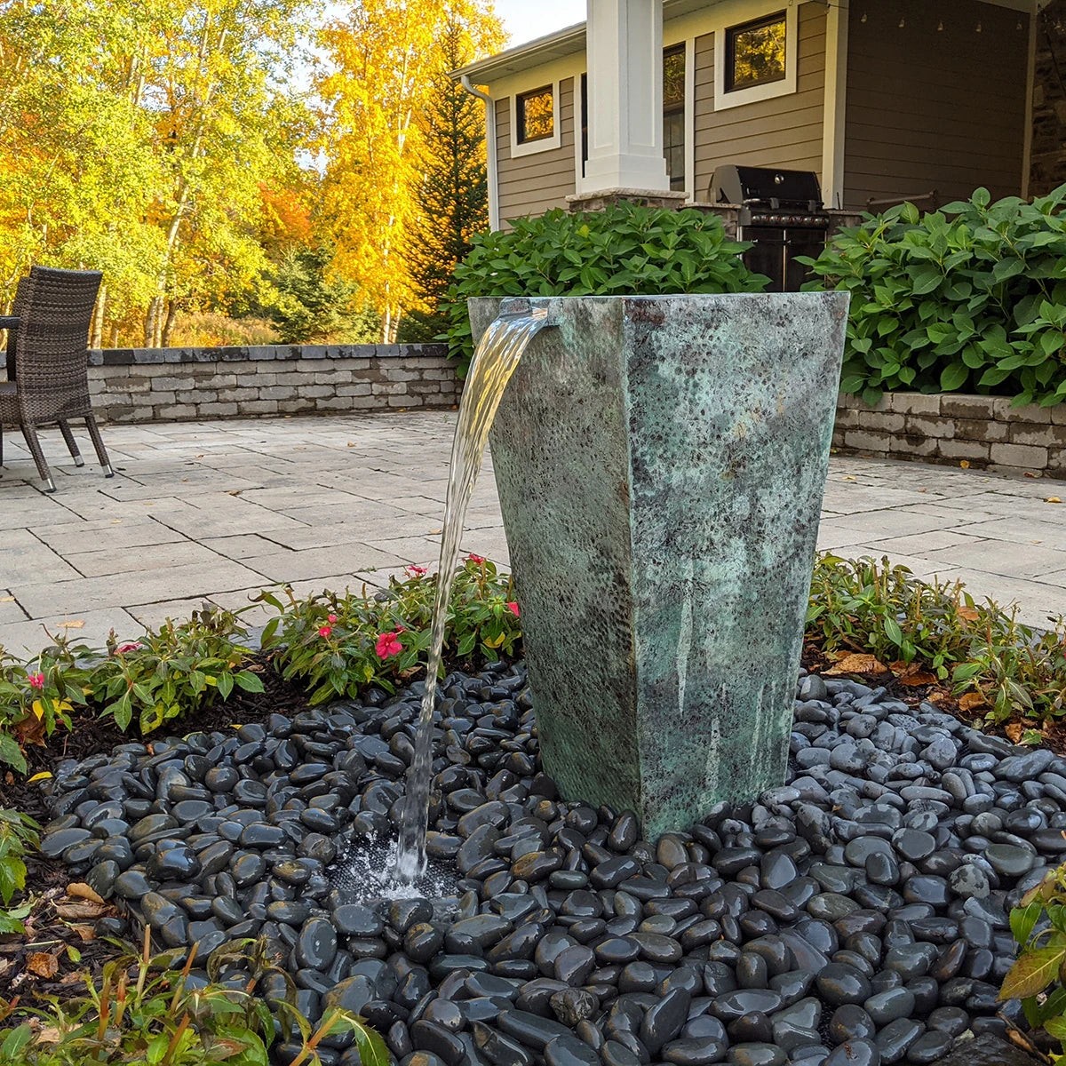 Single tapered square urn fountain lit at night