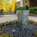 Single tapered square urn fountain lit at night